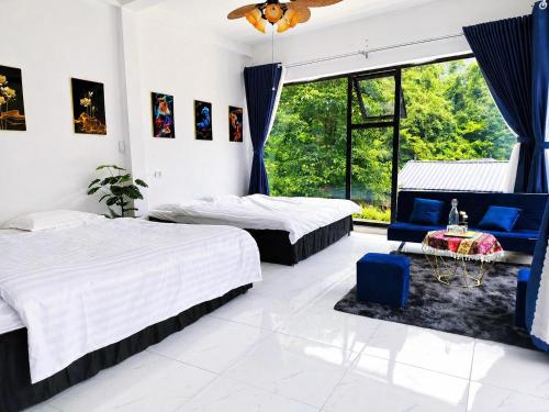a bedroom with two beds and a blue chair at Sam Hotel Lào Cai in Pu Chu Chay