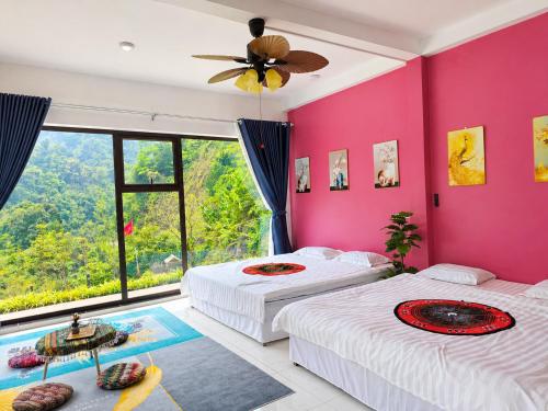 two beds in a room with pink walls at Sam Hotel Lào Cai in Pu Chu Chay