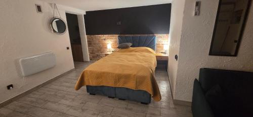 a bedroom with a bed with a yellow blanket on it at Apartament Nova Kamienica - Studio in Łagów