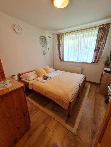 a bedroom with a bed with a cat laying on it at Ubytovanie Lienka in Nová Lesná
