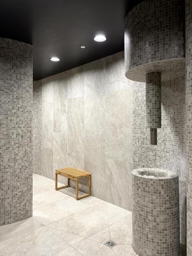a room with a bench and a wall with tiles at Omega Lake Apartament Olsztyn in Olsztyn