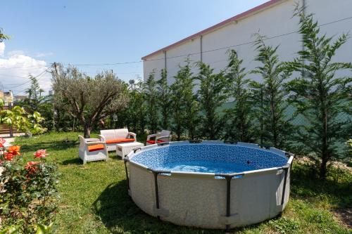 a large tub sitting in the grass in a yard at "Olive & Bloom" entire vila with Pool & Private Parking in Berat