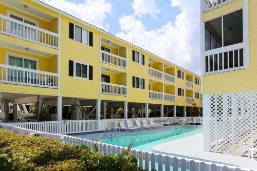 ein großes gelbes Gebäude mit einem Pool neben einem Gebäude in der Unterkunft Sandy Shores III by Capital Vacations in Myrtle Beach