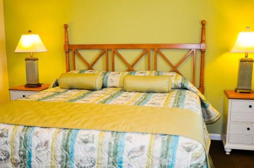 ein Schlafzimmer mit einem Bett mit zwei Lampen und zwei Tischen in der Unterkunft Sandy Shores III by Capital Vacations in Myrtle Beach