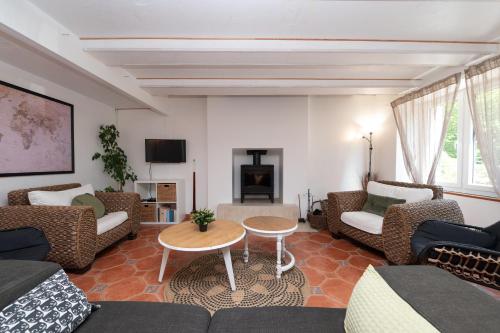 a living room with a couch and chairs and a fireplace at Maison familiale 10 personnes in Bannalec