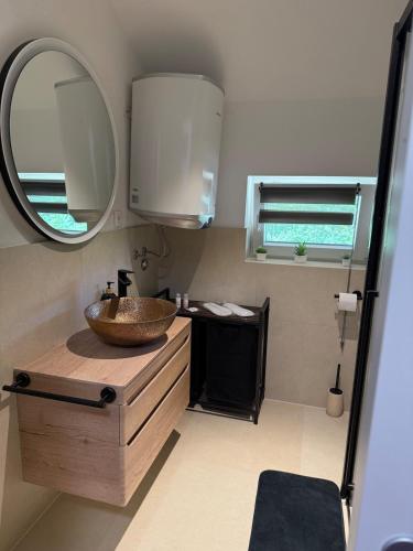 a bathroom with a sink and a mirror at Studio apartman StelLar in Otavice