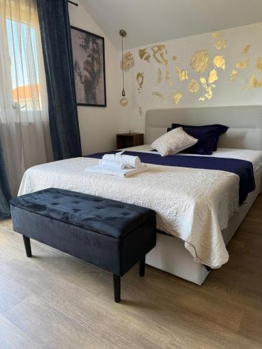 a bedroom with a large bed with a ottoman on it at Studio apartman StelLar in Otavice