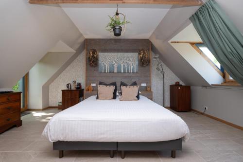 a bedroom with a large bed in a attic at Maison D'hôtes De Calzac Moulin - in Le Gorvello