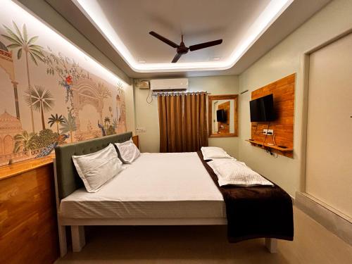 a bedroom with a bed with a ceiling fan at ADITI ROOMS in Tiruchirappalli