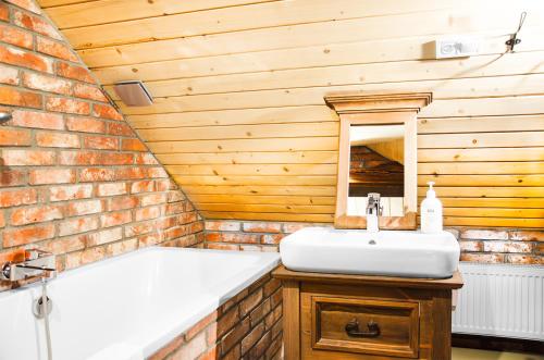 a bathroom with a sink and a bath tub at Ułańska Zagroda in Człopa