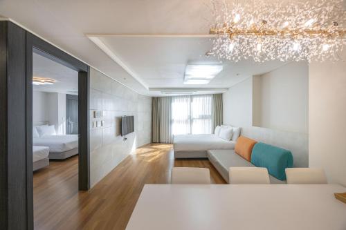 a living room with a couch and a bedroom at Ciel de Mer in Busan