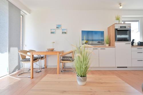 a kitchen with a table with chairs and a tv at Ferienhaus Keona Im Winkel in Dahme