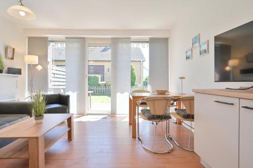 a living room with a table and a kitchen at Ferienhaus Keona Im Winkel in Dahme