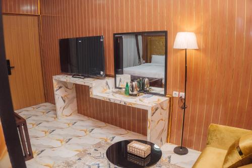 a room with a bedroom with a bed and a television at MIK Resort & Hotel in Pasuruan