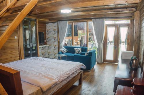 a bedroom with a bed and a blue couch at MIK Resort & Hotel in Pasuruan