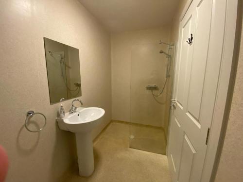 a white bathroom with a sink and a shower at Housegarth in Twatt
