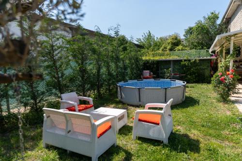 a garden with two chairs and a hot tub at "Olive & Bloom" entire vila with Pool & Private Parking in Berat
