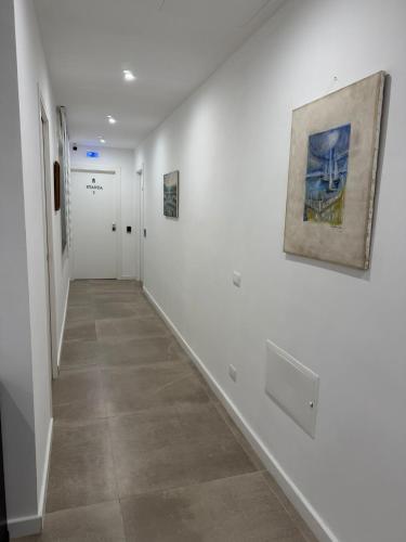 a hallway with white walls and a painting on the wall at B&B Sparta in Crotone
