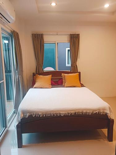 a bedroom with a large bed with yellow pillows at Elevated Bungalow House 5 min from the beach 3-6 in Nathon Bay
