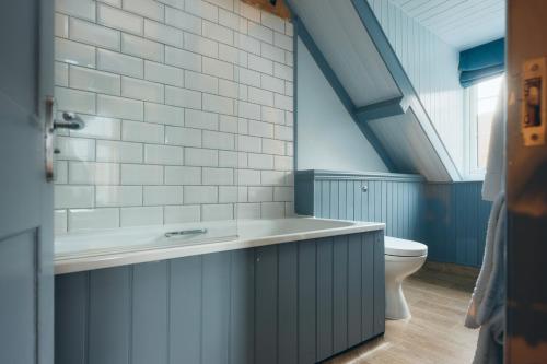 a bathroom with a tub and a toilet at Port Gaverne Hotel in Port Isaac