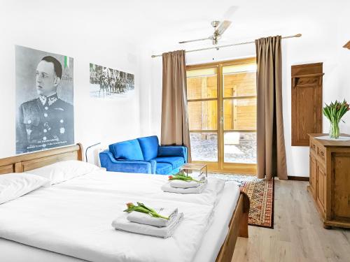 a bedroom with a bed and a blue chair at Ułańska Zagroda in Człopa