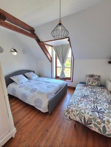 a bedroom with a bed and a window at Le Longbeach 1 in Longueville