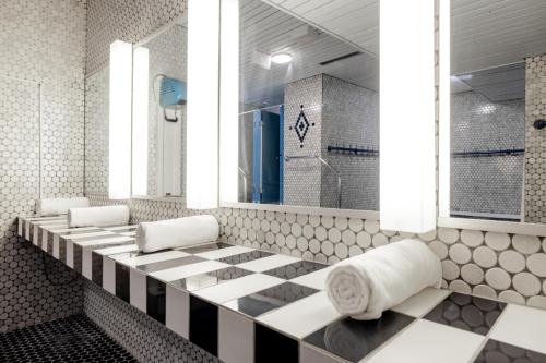 a bathroom with a black and white checkered floor at Hotel Altein Arosa, a Faern Collection Resort in Arosa