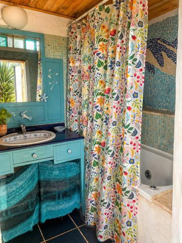 a bathroom with a sink and a shower curtain at The Good Vibes Home in Hoya de Pineda