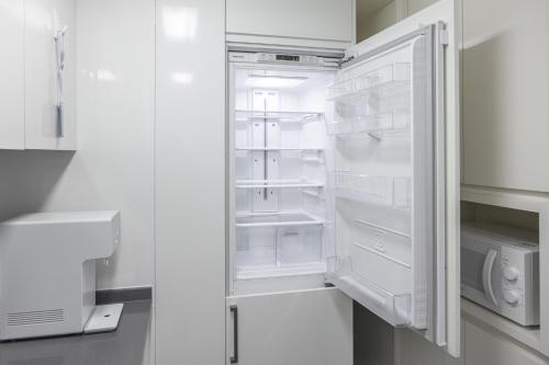 an empty refrigerator with its door open in a kitchen at Ciel de Mer in Busan