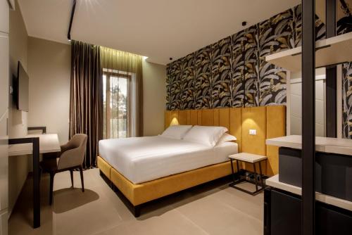 a hotel room with a bed and a desk at Fly Suite Rome Airport in Fiumicino