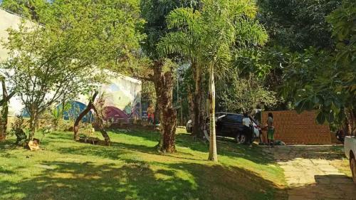 eine Gruppe von Bäumen in einem Garten mit einem Auto in der Unterkunft Escalarte - Gruta da Lapinha in Lagoa Santa