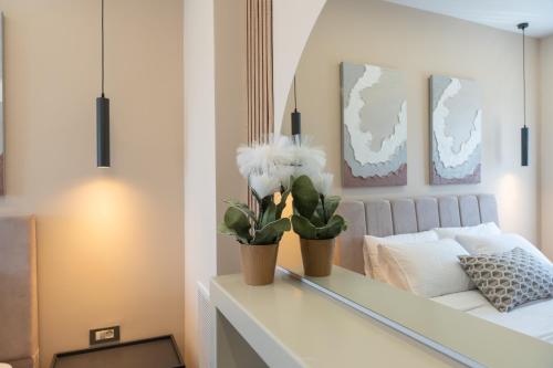 a bedroom with a bed and two plants on a table at Antaia 4 in Nafplio