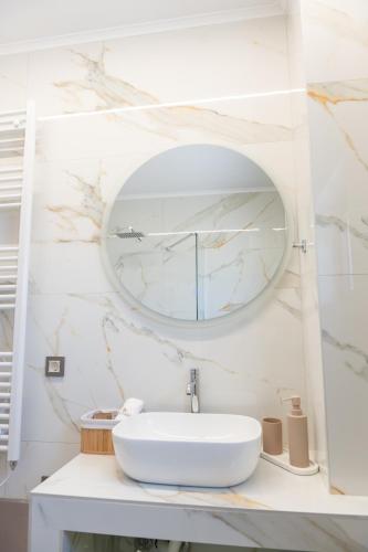 a bathroom with a white sink and a mirror at Antaia 4 in Nafplio