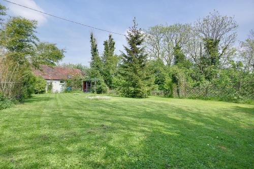 a large yard with a house in the background at The Stables Hill Top Farm in Haselbury Bryan