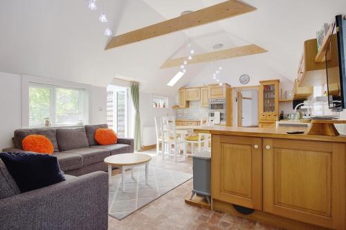 a kitchen and living room with a couch and a table at The Stables Hill Top Farm in Haselbury Bryan