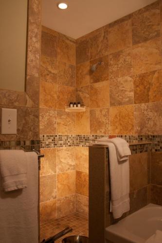 a bathroom with a shower and a sink and a tub at Showers Inn in Bloomington