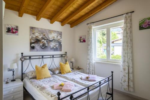 a bedroom with a bed with yellow and pink pillows at Albicocca in Tignale