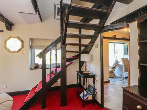 a room with a spiral staircase in a house at Pine Cottage in Hathersage