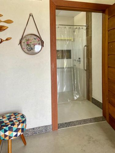 a shower in a room with a glass door at CAMALEÃO Ecopousada Ltda in Linhares