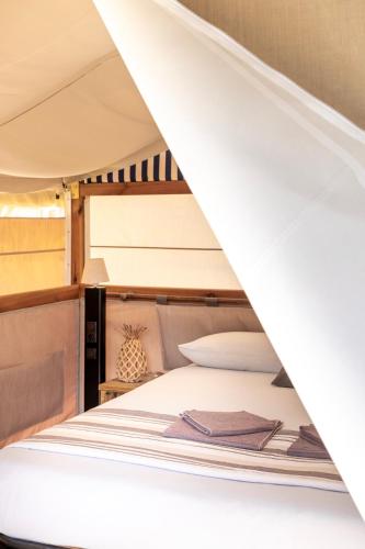 a bunk bed in a boat with a ladder at Glamping Italia 90 Mini Lodges in Domaso