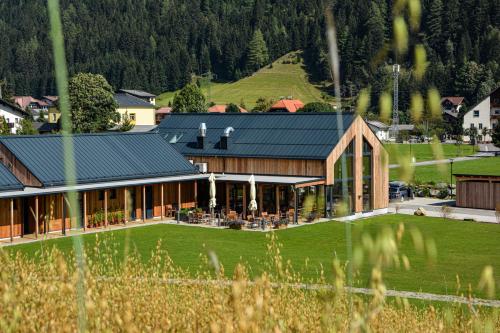 a large house with a green lawn in front of it at Camping HOCHoben - ONLY EMPTY LOTS in Mallnitz