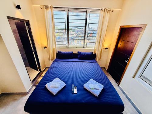 a large blue bed in a room with a window at Villa Govindaraj in Pondicherry