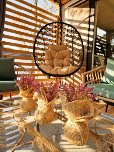 a room with a rattan table with flowers and a chair at Mobile Homes MaLu in Biograd na Moru