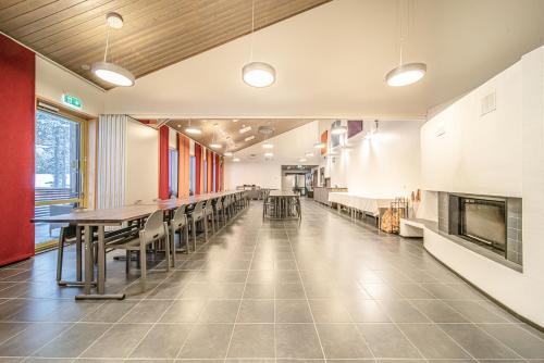 a large room with tables and chairs in it at Wellevi Rooms by Aavalevi in Levi