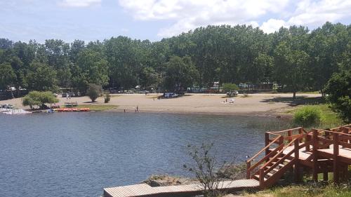 a beach with a wooden bridge and a body of water at Vientos de Chauquen in Panguipulli