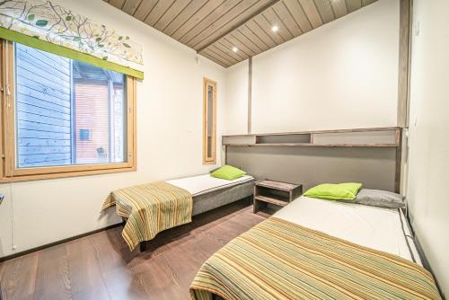 a room with two beds and a window at Wellevi Rooms by Aavalevi in Levi