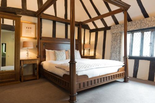 a bedroom with a canopy bed and a window at Best Western The Rose & Crown Hotel in Colchester