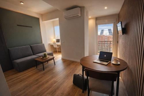 a living room with a couch and a table with a laptop at Winahost Madrid Towers II in Madrid