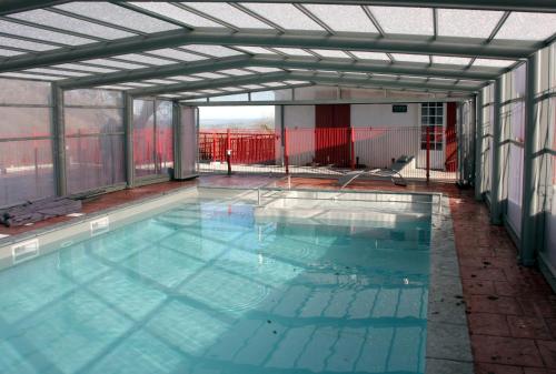 een binnenzwembad met een groot zwembad bij Hotel du Col d'Osquich in Musculdy