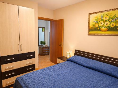 a bedroom with a blue bed and a painting on the wall at Sea view apartment 1 in Shëngjin